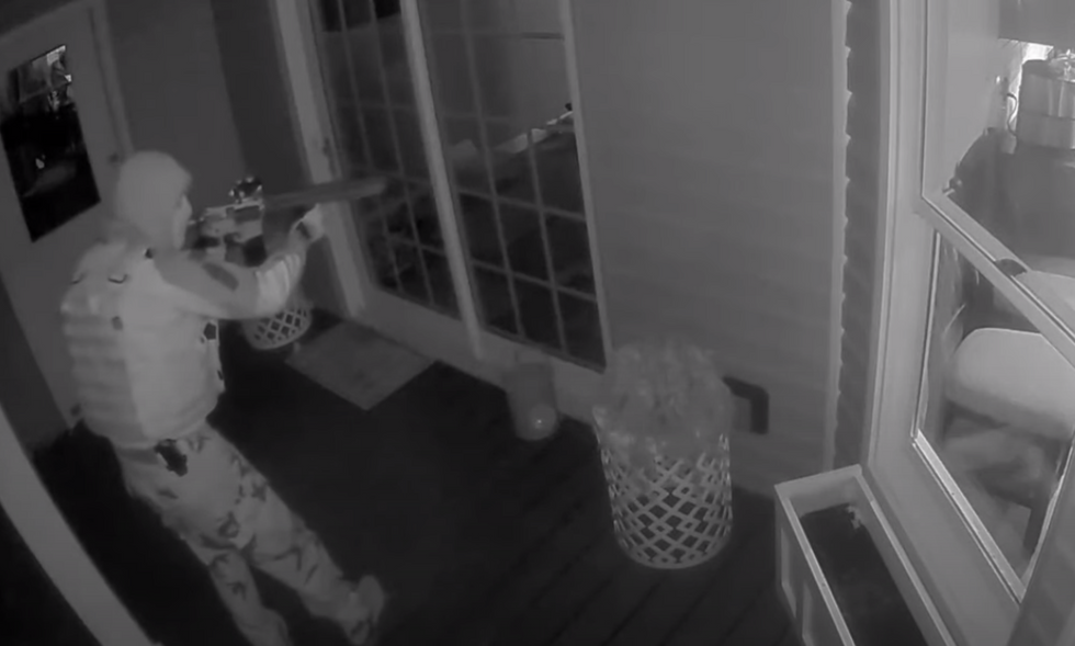'There’s somebody at our back door with a gun': Scary home video shows camouflaged intruder seemingly forgot to load his gun