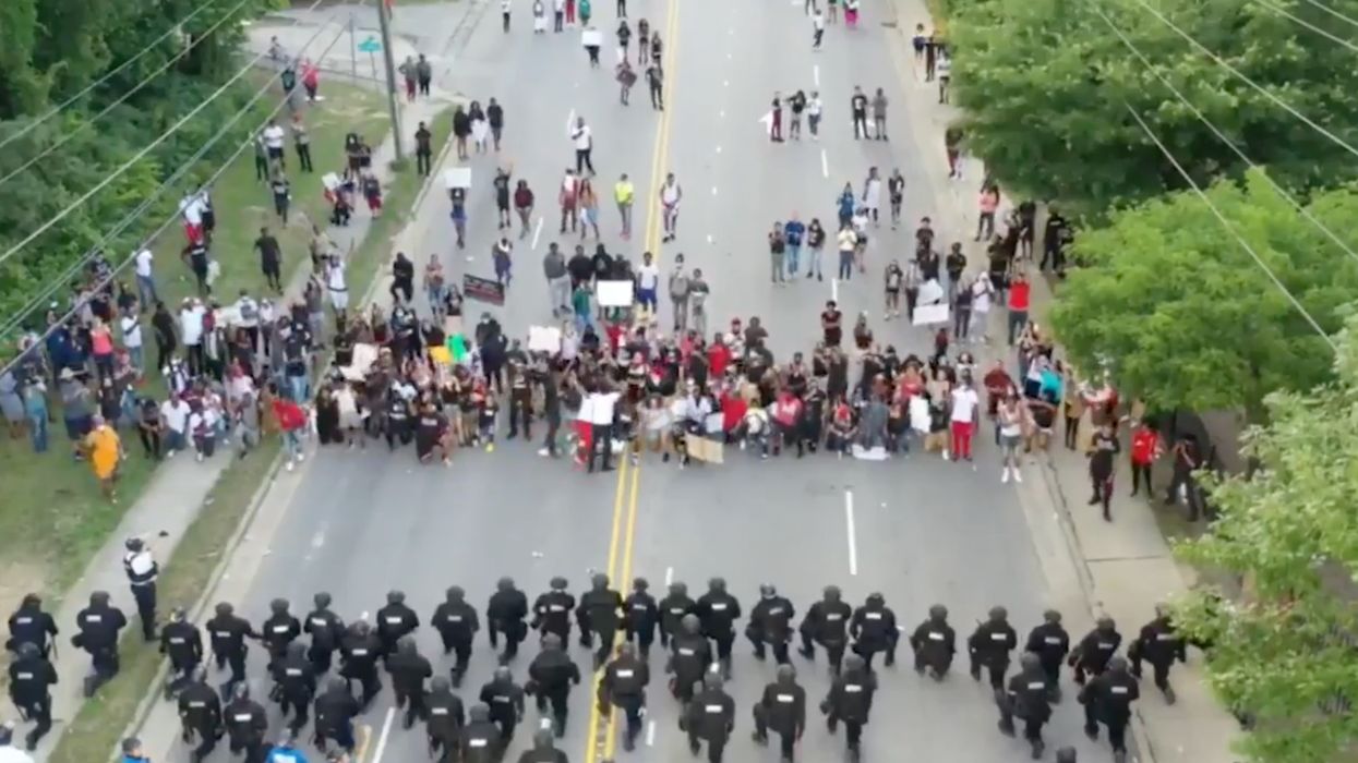 Video captures the moment more than 50 police officers take a knee in solidarity with protesters