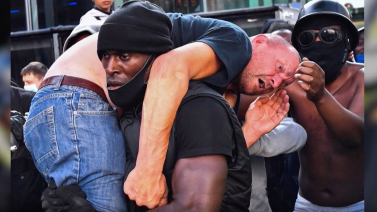 White protester nearly gets stomped during event. Black Lives Matter activist carries him to safety.