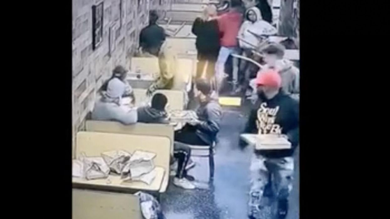 Wild surveillance video captures the moment a pizzeria owner tries to break up a brawl, ends up knocked unconscious and stomped