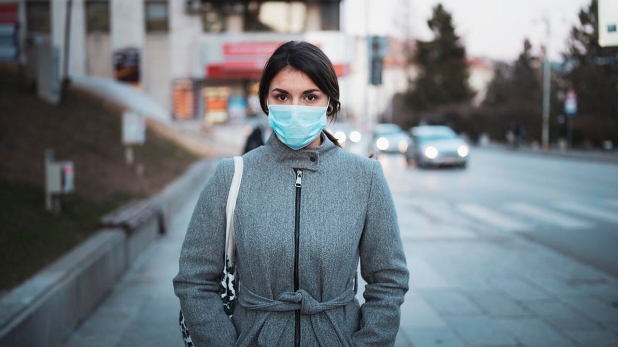Young woman in coat and mask
